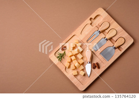 Cubed cheddar, gouda, or parmesan cheese on a cutting board. Cubed cheese 135764120