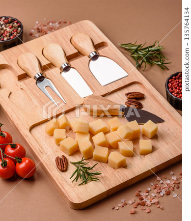 Cubed cheddar, gouda, or parmesan cheese on a cutting board. Cubed cheese Cubed cheddar, gouda, or parmesan cheese on a cutting board. Cubed cheese 135764134