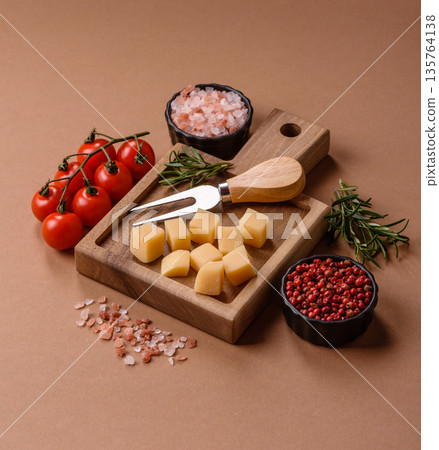 Cubed cheddar, gouda, or parmesan cheese on a cutting board. Cubed cheese Cubed cheddar, gouda, or parmesan cheese on a cutting board. Cubed cheese 135764138