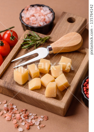 Cubed cheddar, gouda, or parmesan cheese on a cutting board. Cubed cheese Cubed cheddar, gouda, or parmesan cheese on a cutting board. Cubed cheese 135764142