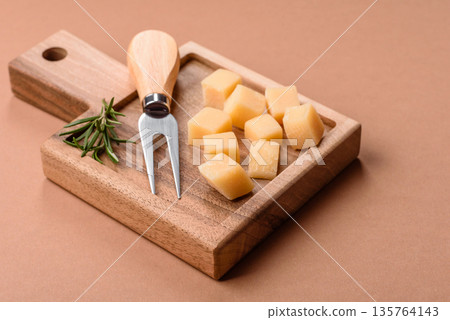 Cubed cheddar, gouda, or parmesan cheese on a cutting board. Cubed cheese Cubed cheddar, gouda, or parmesan cheese on a cutting board. Cubed cheese 135764143