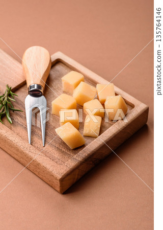 Cubed cheddar, gouda, or parmesan cheese on a cutting board. Cubed cheese Cubed cheddar, gouda, or parmesan cheese on a cutting board. Cubed cheese 135764146