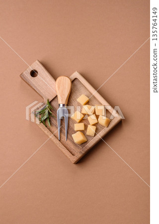 Cubed cheddar, gouda, or parmesan cheese on a cutting board. Cubed cheese Cubed cheddar, gouda, or parmesan cheese on a cutting board. Cubed cheese 135764149