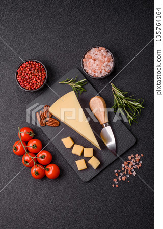 A wedge of cheddar, gouda, or parmesan cheese on a cutting board. Cheese wedge A wedge of cheddar, gouda, or parmesan cheese on a cutting board. Cheese wedge 135764164
