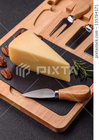 A wedge of cheddar, gouda, or parmesan cheese on a cutting board. Cheese wedge A wedge of cheddar, gouda, or parmesan cheese on a cutting board. Cheese wedge 135764171