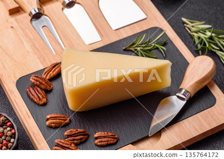 A wedge of cheddar, gouda, or parmesan cheese on a cutting board. Cheese wedge A wedge of cheddar, gouda, or parmesan cheese on a cutting board. Cheese wedge 135764172