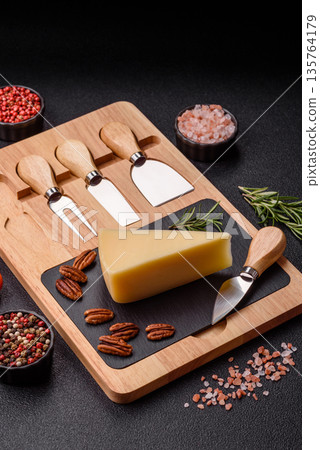 A wedge of cheddar, gouda, or parmesan cheese on a cutting board. Cheese wedge A wedge of cheddar, gouda, or parmesan cheese on a cutting board. Cheese wedge 135764179