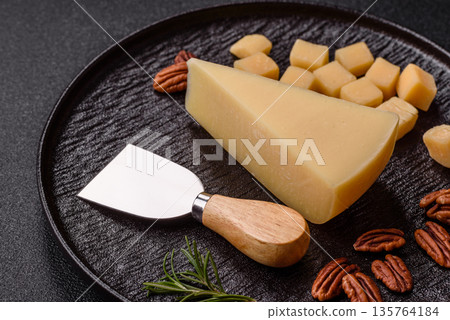 A wedge of cheddar, gouda, or parmesan cheese on a cutting board. Cheese wedge A wedge of cheddar, gouda, or parmesan cheese on a cutting board. Cheese wedge 135764184