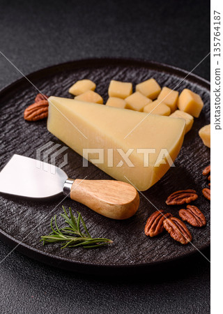 A wedge of cheddar, gouda, or parmesan cheese on a cutting board. Cheese wedge A wedge of cheddar, gouda, or parmesan cheese on a cutting board. Cheese wedge 135764187