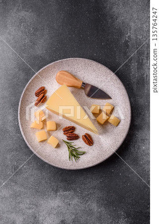 A wedge of cheddar, gouda, or parmesan cheese on a cutting board. Cheese wedge A wedge of cheddar, gouda, or parmesan cheese on a cutting board. Cheese wedge 135764247