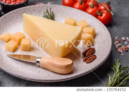 A wedge of cheddar, gouda, or parmesan cheese on a cutting board. Cheese wedge A wedge of cheddar, gouda, or parmesan cheese on a cutting board. Cheese wedge 135764252