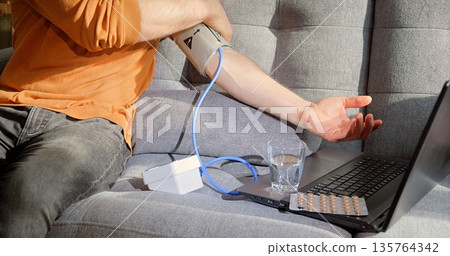 Modern Telemedicine Scene Showing Person Monitoring Health Statistics During Office Tasks At Home Modern Telemedicine Scene Showing Person Monitoring Health Statistics During Office Tasks At Home 135764342