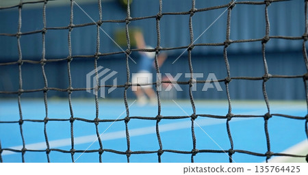 Action Shot Of Tennis Match, Player Executing Powerful Tennis Serve Over Vibrant Court Surface Action Shot Of Tennis Match, Player Executing Powerful Tennis Serve Over Vibrant Court Surface 135764425