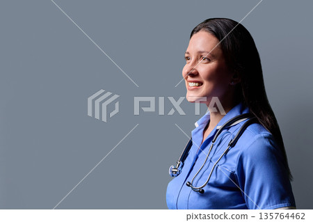 Profile portrait of middle-aged woman doctor, nurse on grey studio background 135764462