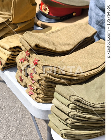 Stacks of folded caps with red stars at a military market or fair 135764650