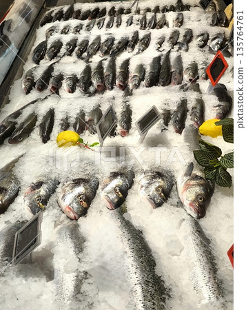 Fresh fish on an ice display at a fish store Fresh fish on an ice display at a fish store 135764761