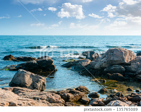 rocky shore of the sea coast under blue sky. beautiful view of coastal bulgaria on a sunny day. resort scenery near sozopol during vacation season in summer. place for vacation, retreats and escape rocky shore of the sea coast under blue sky. beautiful view of coastal bulgaria on a sunny day. resort scenery near sozopol during vacation season in summer. place for vacation, retreats and escape 135765089