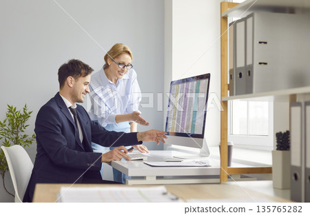 Business people working in office sitting with pc computer with tables and charts. Business people working in office sitting with pc computer with tables and charts. 135765282