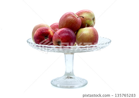 Ripe garden apples in a transparent fruit bowl. Isolated object for healthy eating, diet, harvest, and cozy kitchen interior themes. 135765283