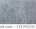 Macro shot of a soft textile surface with pile. Neutral gray background for design showing a cozy texture of fabric, carpet, or blanket 135765291