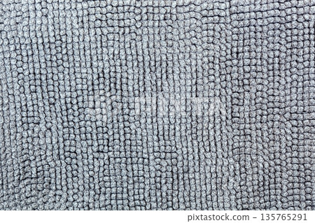 Macro shot of a soft textile surface with pile. Neutral gray background for design showing a cozy texture of fabric, carpet, or blanket 135765291