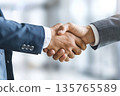 Hands of a businessman in a suit shaking hands in a business office to sign a contract 135765589