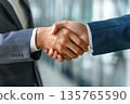 Hands of a businessman in a suit shaking hands in a business office to sign a contract 135765590