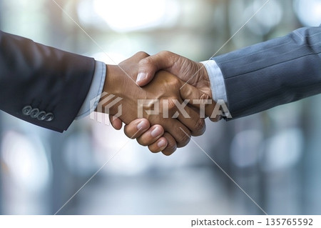 Hands of a businessman in a suit shaking hands in a business office to sign a contract 135765592
