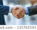 Hands of a businessman in a suit shaking hands in a business office to sign a contract 135765593