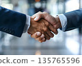 Hands of a businessman in a suit shaking hands in a business office to sign a contract 135765596