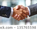 Hands of a businessman in a suit shaking hands in a business office to sign a contract 135765598