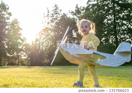 Airplane costume. Toddler imagination flying. Girl outdoor yellow grass fun. Airplane costume. Toddler imagination flying. Girl outdoor yellow grass fun. 135766023