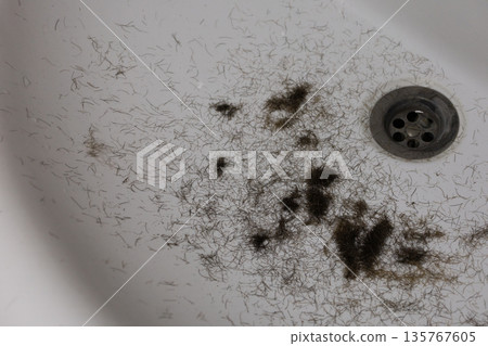 Man trimming beard and beard clippings in sink Man trimming beard and beard clippings in sink 135767605