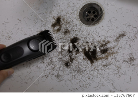 Man trimming beard and beard clippings in sink Man trimming beard and beard clippings in sink 135767607