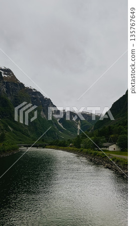 A boat water in front of mountain. Water calm and clear.  135767649
