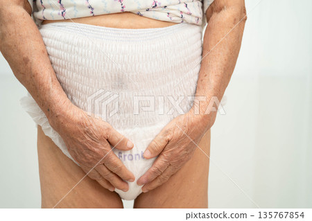 Asian senior woman patient wearing adult incontinence diaper pad in hospital. 135767854