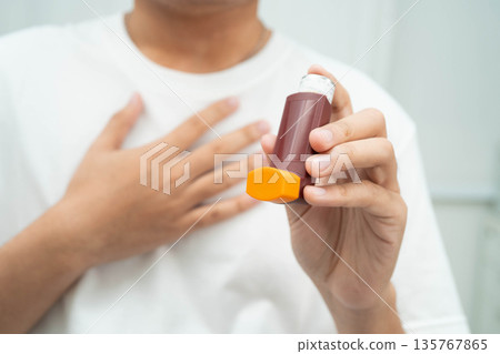 Asthma and chronic obstructive pulmonary disease COPD, Asian teenage using metered dose inhaler MDI. Asthma and chronic obstructive pulmonary disease COPD, Asian teenage using metered dose inhaler MDI. 135767865