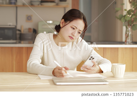 一位年輕女子一邊寫作一邊思考 135771023