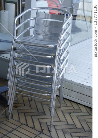 Plastic folding chairs stacked in a restaurant cafe 135771136