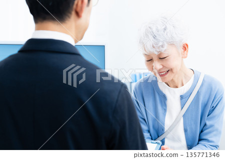 Senior woman completing procedures at the counter 135771346