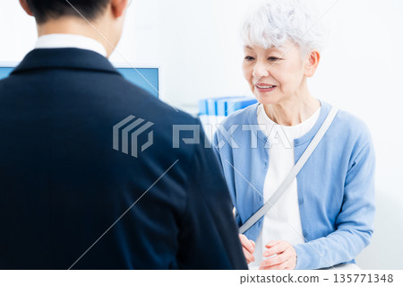 Senior woman completing procedures at the counter Senior woman completing procedures at the counter 135771348