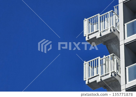 Modern White Balconies on a Building against Blue Sky. 135771878