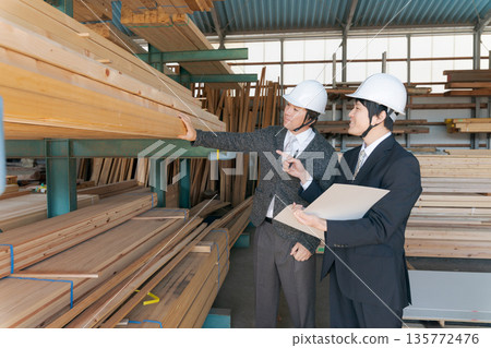 Men in suits looking at lumber at a lumberyard Men in suits looking at lumber at a lumberyard 135772476