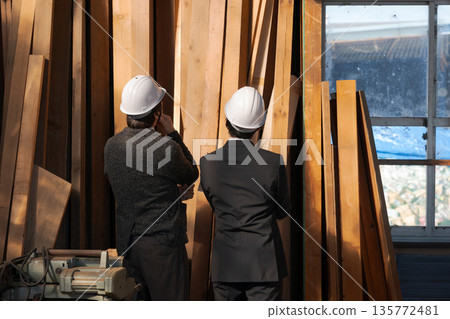 The backs of men in suits looking at wood 135772481