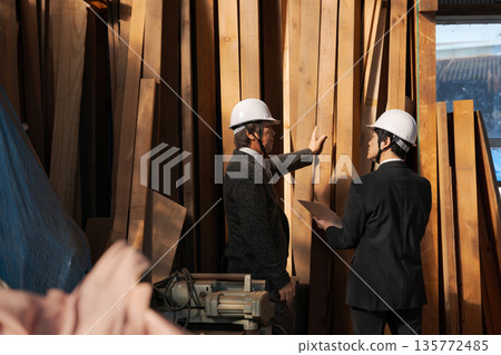 Men in suits looking at lumber at a lumberyard Men in suits looking at lumber at a lumberyard 135772485