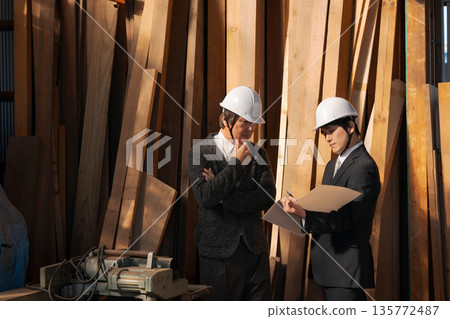 Men in suits looking at lumber at a lumberyard Men in suits looking at lumber at a lumberyard 135772487