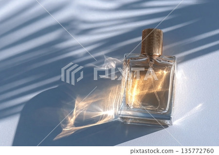 A chic cosmetic glass bottle lies on thin parallel shade lines in the rays of the sun. A copy space. A blank bottle mockup. product advertising 135772760