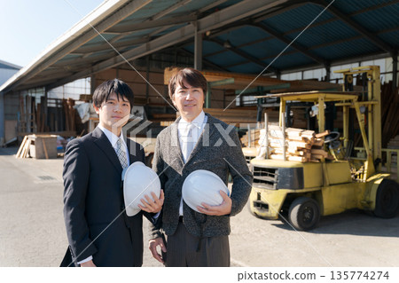 Men in suits standing in front of a lumber mill 135774274