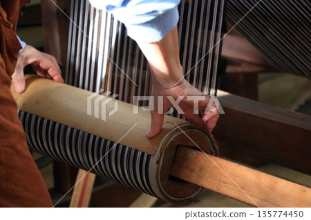 Warp threads being wound on a warping machine at the Chichibu Meisen Museum Warp threads being wound on a warping machine at the Chichibu Meisen Museum 135774450