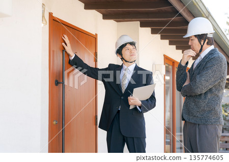 Men in suits having a meeting in front of a house Men in suits having a meeting in front of a house 135774605